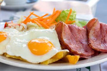 Fried eggs with bacon and salad