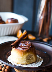 Cinnabon cinnamon rolls, almonds and mandarins on a dark plate