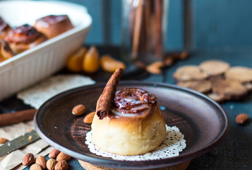 Cinnabon cinnamon rolls, almonds and mandarins on a dark plate