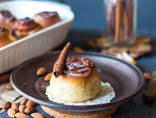 Cinnabon cinnamon rolls, almonds and mandarins on a dark plate
