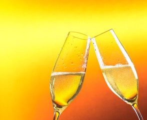 two flutes of champagne with golden bubbles and space for text