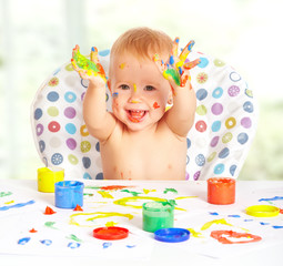 Obraz premium happy baby child draws with colored paints hands