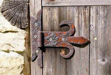 Old rusty hinge on wooden door