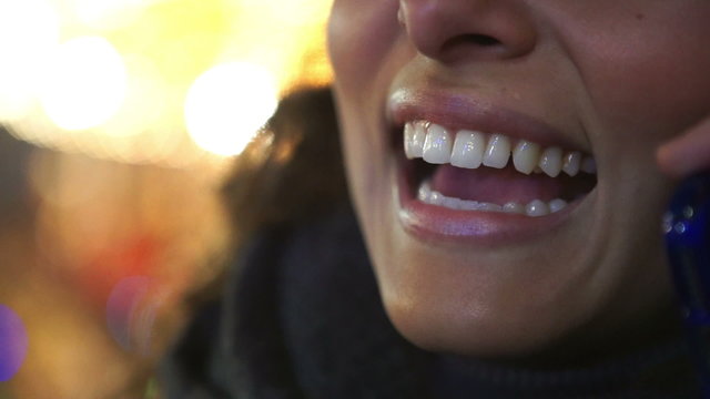 Close up of lips talking on a mobile cell phone at night