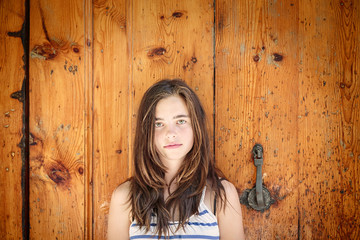 Fototapeta premium portrait of a beautiful teenage girl in front of an ancient wood