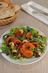 Salad greens with persimmon, pomegranate and cashews