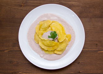 Ravioli with radicchio sauce on wooden table seen from above