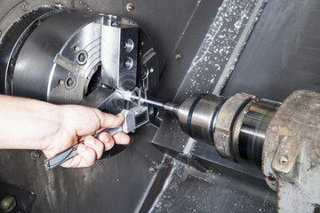 Operator measuring drilled parts