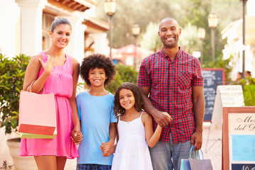 Portrait Of Family Walking Along Street With Shopping Bags