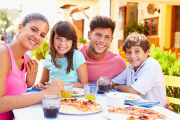 Portrait Of Family Eating Meal At Outdoor Restaurant