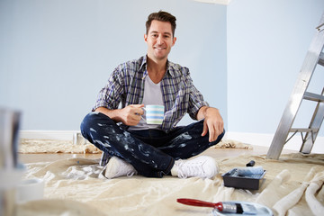 Portrait Of Man Decorating Nursery For New Baby