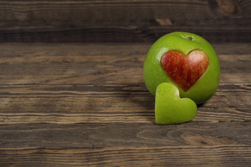 Apple in the shape of a heart on wooden planks