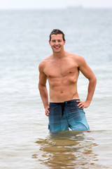 man walking out of the water in tropical beach
