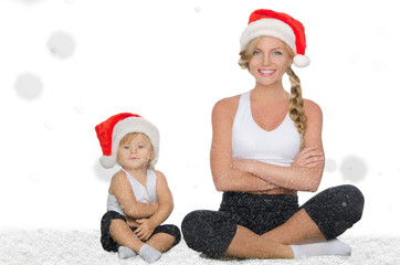 Mom and daughter doing yoga in Christmas hats