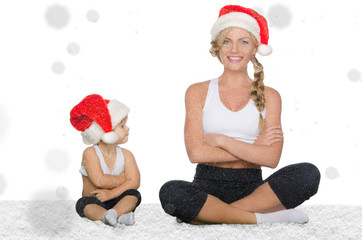 Mom and daughter doing yoga under falling snow