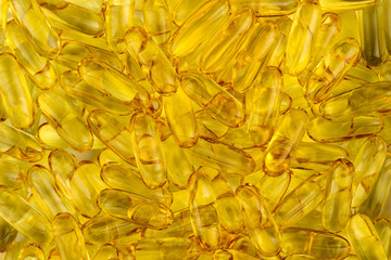 Yellow background texture of omega fatty acid fish oil capsules