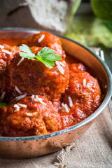 Closeup of meatballs in tomato sauce with parsley