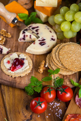 soft cheese with fruits, oat crackers and basil