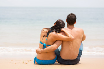 young couple sitting on beach