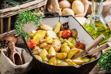 Freshly baked potatoes with tomatoes, garlic and rosemary