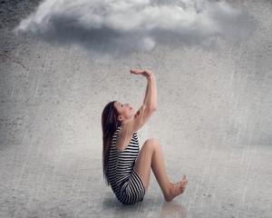 Disappointed young businesswoman with raincloud above her head