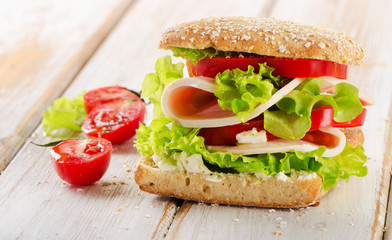 Sandwich with  fresh tomatoes on   wooden table