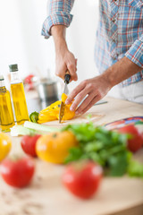 closeup on man's hands cutting vegetables