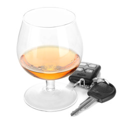 Glass of alcoholic drink and car key, isolated on white