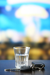 Glass of alcoholic drink and car key,