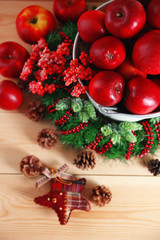 Fototapeta na wymiar Christmas apples in bucket on wooden table