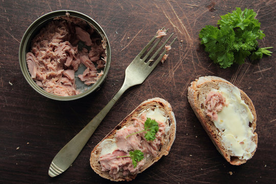 Bread slices with butter and tuna with green parsley