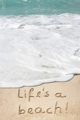 Fototapeta premium Conceptual life is a beach text in sand and water