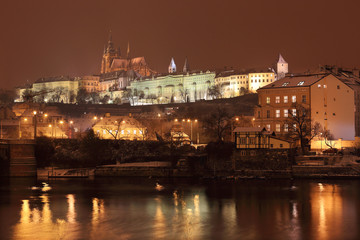 Fototapeta na wymiar Night romantic snowy Prague gothic Castle above River Vltava