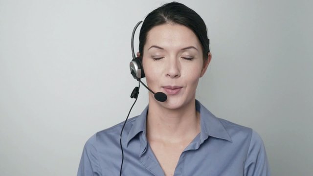 Mitarbeiterin in einem Callcenter spricht mit Headset