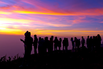 Group of people on top of a mountain waiting for take photo with
