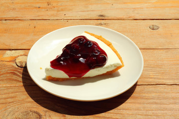 close up blue berry cheese cake in white dish