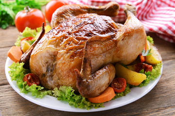 Delicious baked chicken on plate on table close-up