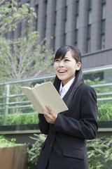 ノートを見て考えるビジネスウーマン