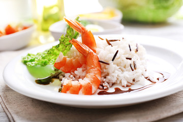 Boiled rice with shrimps served on table, close-up