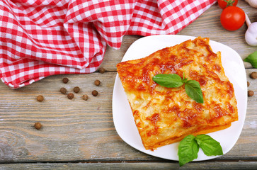 Portion of tasty lasagna on wooden table