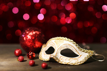 Beautiful carnival mask on table on red background