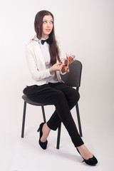Attractive businesswoman with cash sits on chair