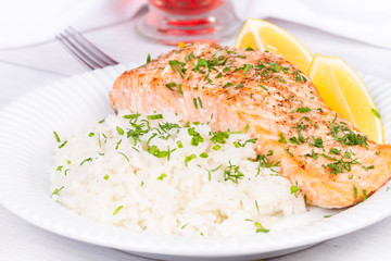 Steamed salmon with fresh herbs and lemon. Rice as a garnish