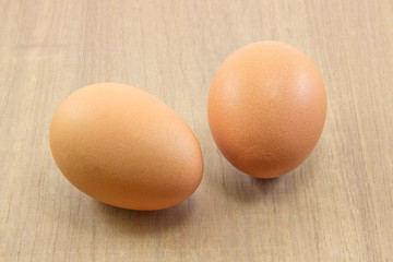 Two raw eggs on wood board