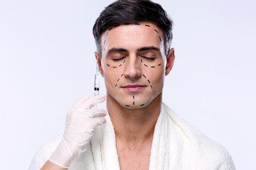 Man preparing for plastic surgery over gray background