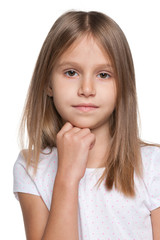 Fototapeta premium Pensive little girl against the white background