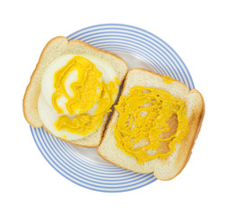 Open faced onion sandwich with mustard on a plate