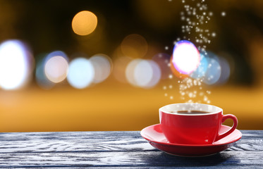 Cup of hot drink on bright background