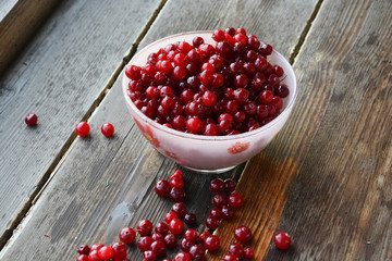 Close-up of cranberries in bowl, on wooden backround