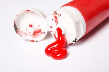 tube of red acrylic paint over white